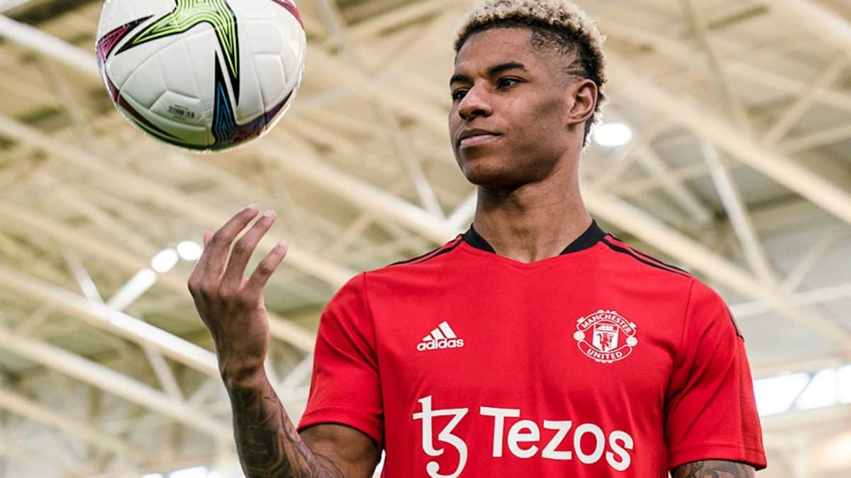 A soccer player throws a ball in the air for Manchester United.