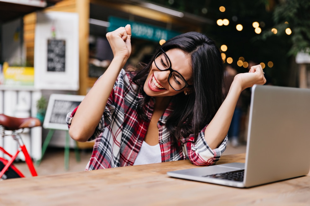 image of a happy woman sitting in front of the laptop