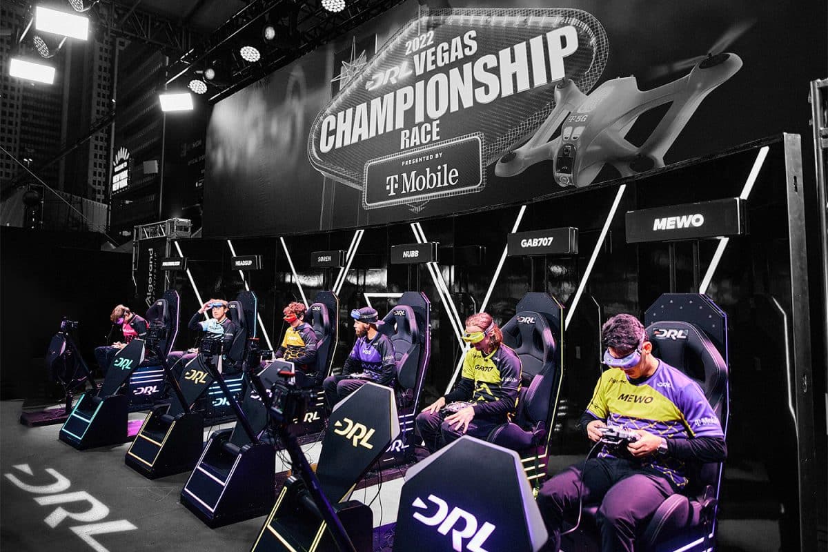 Six competitors sit in chairs during the championships for the Drone Racing League.